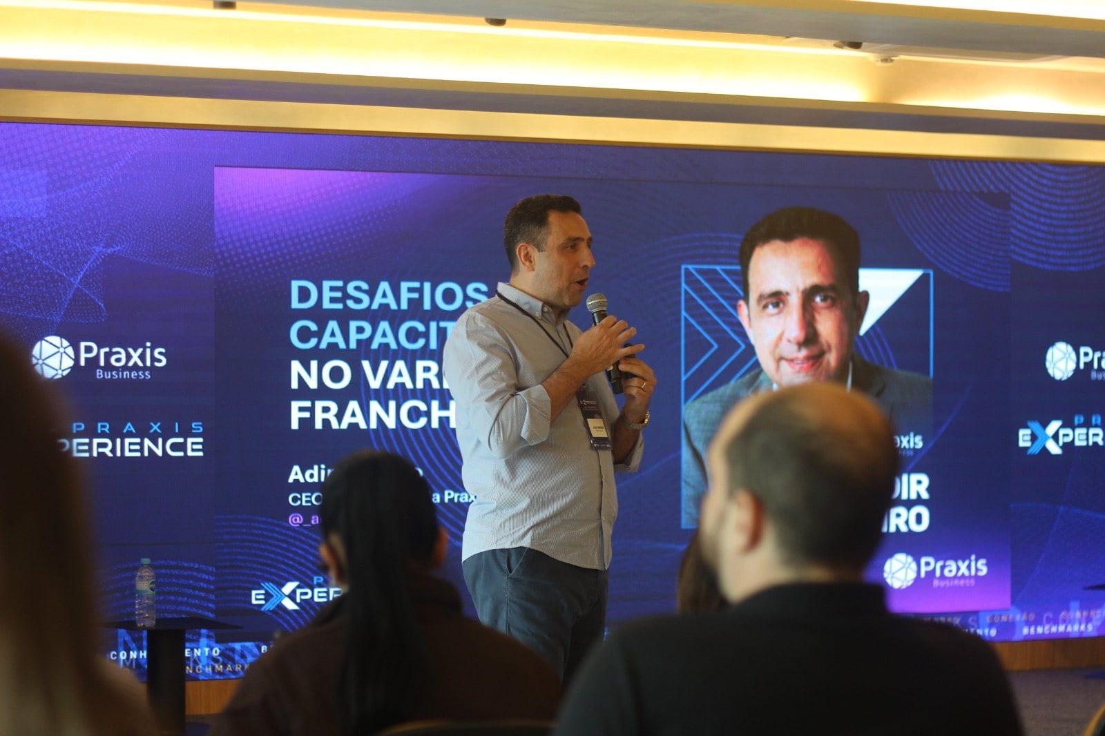 Palestra em uma edição anterior do Praxis Experience, com o painel de LED do evento ao fundo
